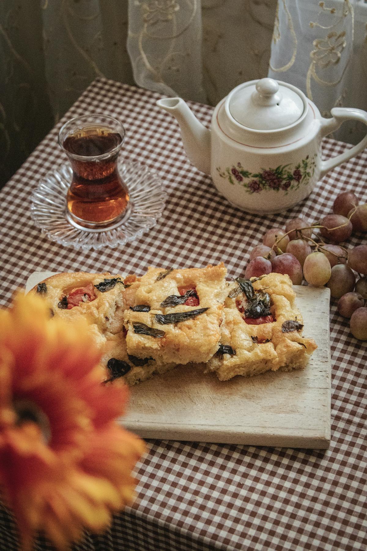 A tray of Italian focaccia with olives, dimpled and glistening with olive oil.